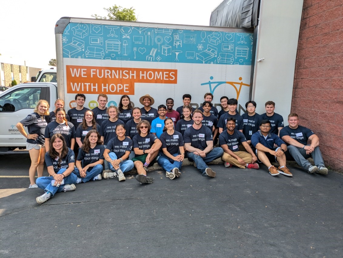 Interns sitting in front of donaltion truck.