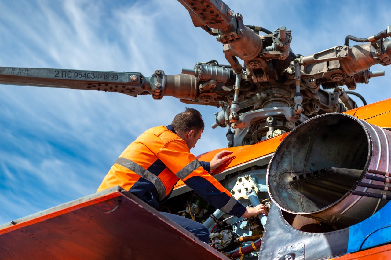 Technician checking helicopter engine