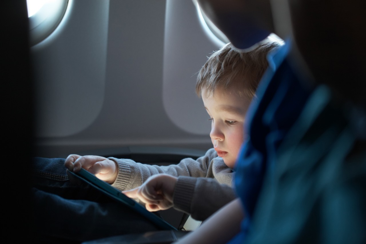 Un enfant utilise une tablette dans l'avion