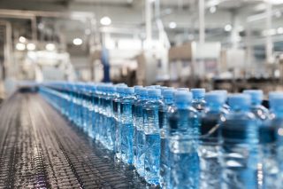 Water factory - Water bottling line for processing and bottling pure spring water into green glass small bottles. Selective focus.; Shutterstock ID 533917285; purchase_order: Food and Beverage; job: Content; client: F&B; other: Jordan