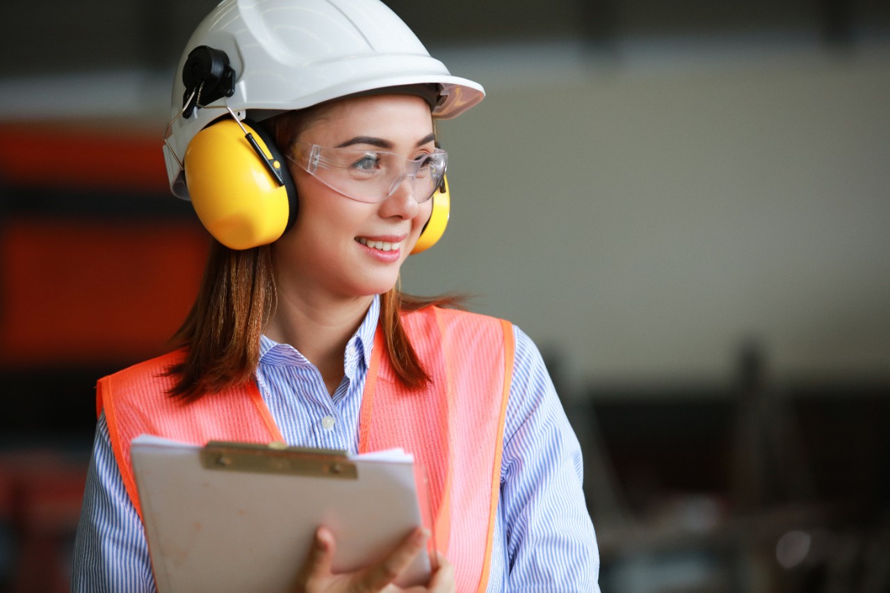Portrait beautiful asia engineer wearing PPE safety helmet , safety glasses , 